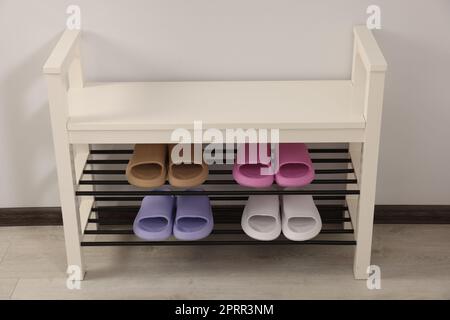Aufbewahrungsbank mit Paar Gummipantoffeln im Innenbereich Stockfoto