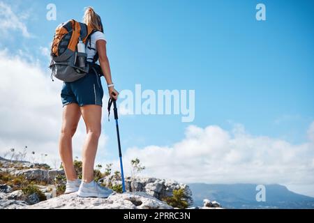 Felsen, Wandern und Frauen auf den Bergen während eines Fitness-Abenteuers oder einer Reise in afrika. Freiheit, blauer Himmel und Mädchen, die während der Wanderung auf einer Klippe stehen Stockfoto