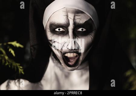 Porträt einer teuflischen Nonne draußen, Nahaufnahme. Halloween-Party-Look Stockfoto