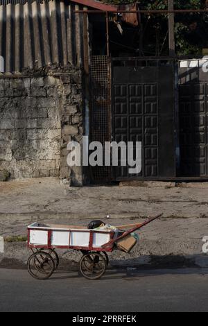 Handkarren auf der Straße vor Gebäuden- urbane Szene Stockfoto