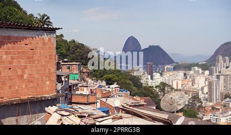 Ein Teil der Stadt ist immer noch von Armut durchsetzt. Slums an einem Berghang in Rio de Janeiro, Brasilien. Stockfoto