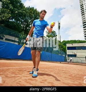 Ein Tennisspieler, der sich bereit macht, zu dienen. Stockfoto