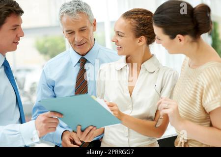 So können wir Profit machen. Eine Gruppe von erfahrenen Geschäftskollegen, die sich über eine neue Geschäftsstrategie discussieren. Stockfoto