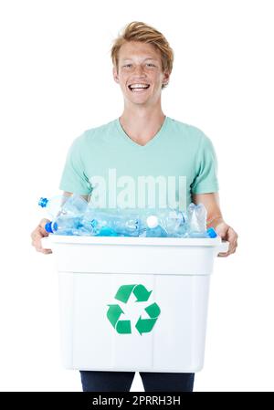 Ich tue meinen Teil für Mutter Erde. Ein glücklicher junger Mann mit rotem Kopf, der einen mit leeren Plastikflaschen gefüllten Recyclingbehälter in der Hand hält. Stockfoto