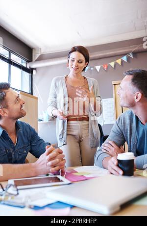 Vorbereitung auf ihre Idee. Drei Mitarbeiter, die ein Treffen in einem kreativen Büro haben. Stockfoto