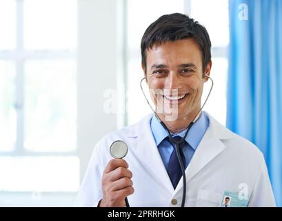 Lassen Sie uns herausfinden, was da drin ist. Porträt eines hübschen jungen Arztes, der lächelt und ein Stethoskop in der Hand hält. Stockfoto