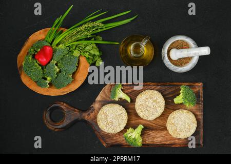 Draufsicht auf halbfertiges hausgemachtes Hühnerschnitzel mit Brokkoli Stockfoto