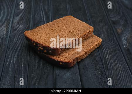 Zwei Stücke braunes Brot auf einem Holztisch Stockfoto