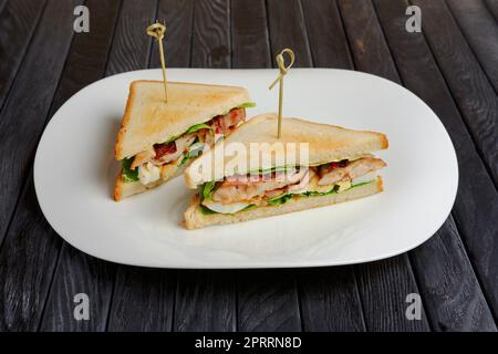 Teller mit Club Sandwich auf Holztisch Stockfoto