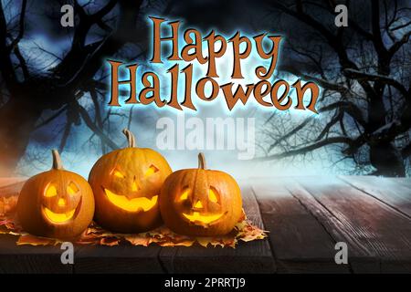 Frohes Halloween. Furchteinflößende Jack O'Lantern Kürbisse umgeben von mystischem Nebel in der Nacht Stockfoto