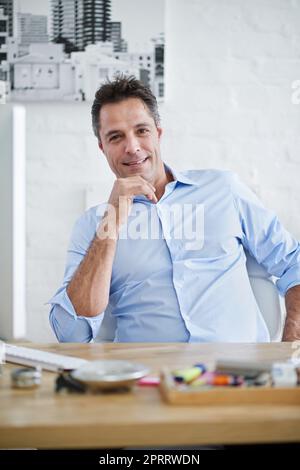 HES ist zuversichtlich, was seinen Job ansieht. Ein gutaussehender Geschäftsmann in seinem Büro. Stockfoto