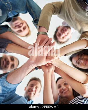 Gemeinsam können wir jede Aufgabe erledigen. Aufnahme einer Gruppe von Mitarbeitern, die ihre Hände übereinander stapeln. Stockfoto