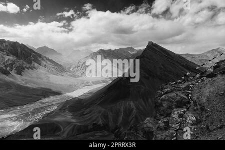 Der Spiti-Fluss, flankiert von hohen Gipfeln des Himalaya unter einem blauen, wolkigen Himmel nahe Kaza, Himachal Pradesh, Indien. Stockfoto