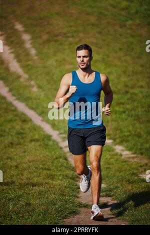 Ein sportlicher junger Mann, der im Freien Kardio macht. Stockfoto