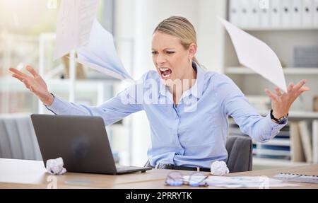 Verärgerte Geschäftsfrau, die Papierdokumente in Stress, Frustration und 404-Laptopfehler im Büro warf. Unternehmer schreien vor Wut wegen Internetproblemen, Burn-out-Krise und Steuerprüfungsfehlern Stockfoto