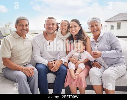 Großes Familienfoto, Kinder mit Großeltern im Sommerurlaub auf Sofa mit blauem Himmel. Frohe mexikanische Mutter, gemischtrassige Vater und Kinder oder Baby, das sich auf der Terrasse im Freien zusammenhält Stockfoto