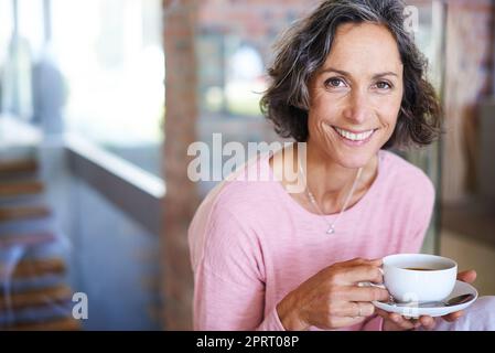 Die erste entspannende Tasse des Tages. Porträt einer reifen Frau, die Kaffee trinkt. Stockfoto