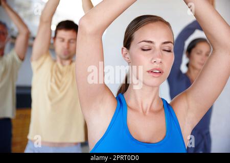 Atmen Sie alle ihre Sorgen und Sorgen aus. Eine kurze Aufnahme einer entspannten Familie, die beim gemeinsamen Yoga ausatmet. Stockfoto