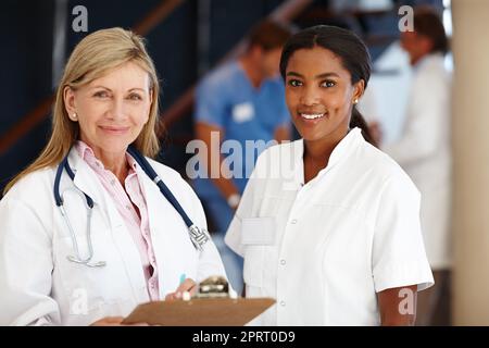 Wie können wir Ihnen helfen? Porträt von zwei lächelnden Ärztinnen. Stockfoto