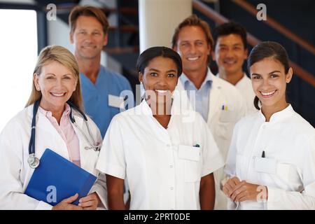Ihre Gesundheit ist unsere Priorität. Eine Gruppe von medizinischen Fachleuten lächelt an der Kamera. Stockfoto