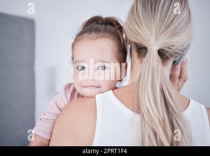 Baby, Kommunikation und mutter, die telefoniert, während sie im geschäftlichen Gespräch multitaskt. Arbeiten von zu Hause aus alleinerziehende Mutter, die ein kleines Mädchen, Kind oder Kind hält, während sie mit einem Mobiltelefon spricht Stockfoto