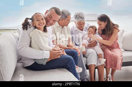 Familie, Kinder und Liebe mit einem Mädchen ihr Vater verbindet sich zu Hause mit ihren Verwandten im Wohnzimmer. Kinder, Eltern und Großeltern, die während eines Besuchs in ihrem Haus auf einem Sofa sitzen Stockfoto