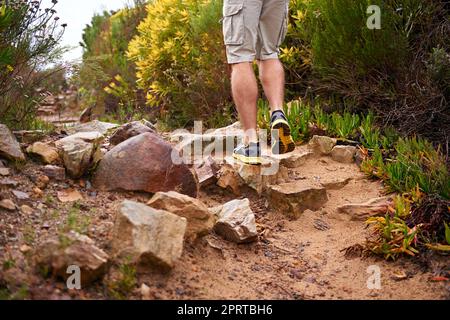 Kauen den Trail. Ein mann Beine, wie er auf einem felsigen Trail wandert. Stockfoto