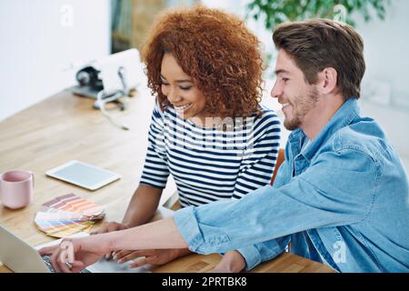 Ein erfolgreiches Team schlägt mit einem Herzen. Zwei Kollegen arbeiten an ihren Schreibtischen zusammen. Stockfoto