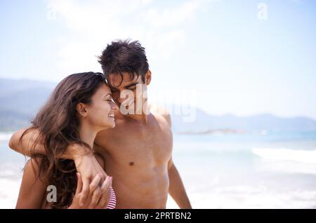 Die Liebe liegt in der Luft. Ein junges Paar genießt einen Strandurlaub. Stockfoto