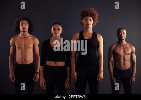 Fokus und Vertrauen für dieses Team. Eine Gruppe von Tänzern, die nebeneinander stehen und die Kamera betrachten. Stockfoto