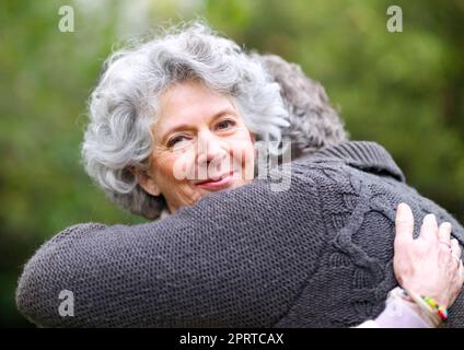 Die Wärme der Liebe. Eine ältere Frau umarmt ihren Mann liebevoll. Stockfoto