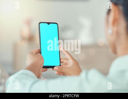 Mockup, Marketing und Werbung auf einem Telefon mit einem blauen Bildschirm in den Händen einer Frau in ihrem Haus. Produktplatzierung, Logo und Marke auf einem mobilen Display für kreatives Website- oder Homepage-Design Stockfoto