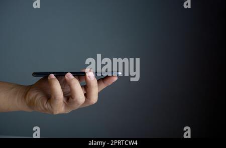 Das Telefon befindet sich auf dem Handdeckel der Person. Konzept der Kommunikationstechnik. Stockfoto