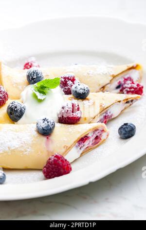 Pankaces gefüllt mit Heidelbeeren, Himbeeren und Rahm Stockfoto