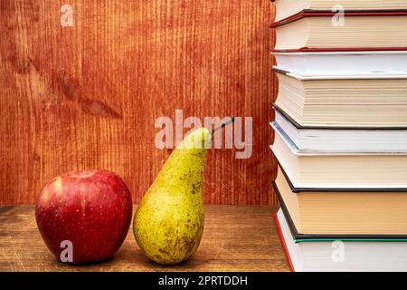 Ein Stapel Bücher, ein Apfel und eine Birne Stockfoto