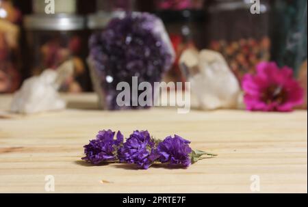 Amethyst-Kristalle mit Blumen auf dem Meditationstisch Stockfoto