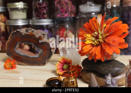 Agatized Coral mit Quarz-Kristallen und Blumen auf dem Meditationstisch Stockfoto