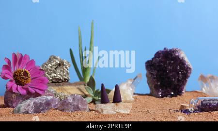 Chakra-Steine und Blumen auf australischem rotem Sand Stockfoto