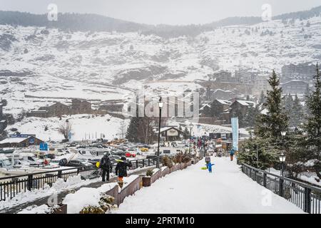 El Tarter, Andorra, Jan 2020 Personen, Familien mit Ski- und Snowboardausrüstung Wandern auf dem Hauptparkplatz mit Skiliften, Pyrenäen Stockfoto