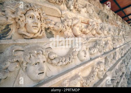 Friesen auf dem Tiberius-Portikus, in dem verschiedene Götter, Göttinnen und Porträtköpfe in Aphrodisias, Aydin, Türkei, abgebildet sind Stockfoto