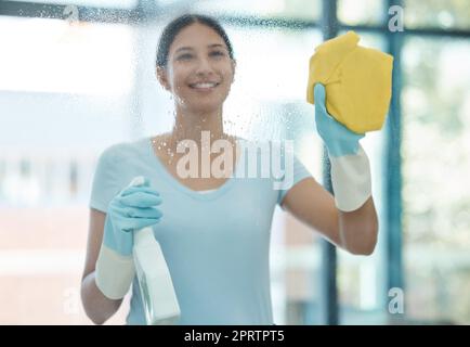 Haus, Fenster und Frau putzen ihre Hausfenster mit Glaswaschreiniger Spray. Frühjahrsputz-Job eines glücklichen Zimmermädchens, Mitarbeiter und Mitarbeiter lächeln, um in einem Haushalt sauber zu machen Stockfoto