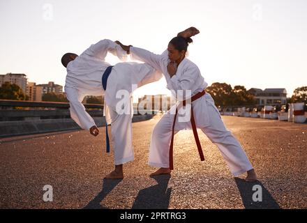 Mit dem Ziel auf ihren Kopf. Zwei Sportler stehen sich gegenüber und üben ihr Karate, während sie GI tragen. Stockfoto