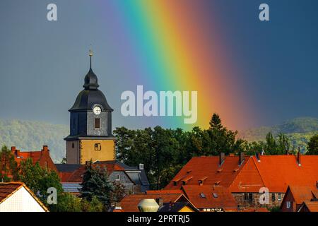 Ein Regenbogen hinter der Kirche von Herleshausen in Hessen Stockfoto