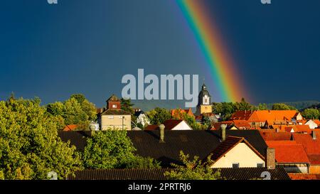 Ein Regenbogen hinter der Kirche von Herleshausen in Hessen Stockfoto