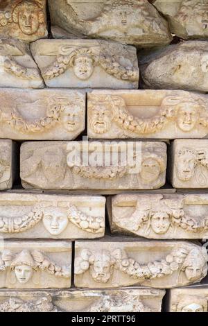 Friesen auf dem Tiberius-Portikus, in dem verschiedene Götter, Göttinnen und Porträtköpfe in Aphrodisias, Aydin, Türkei, abgebildet sind. Stockfoto