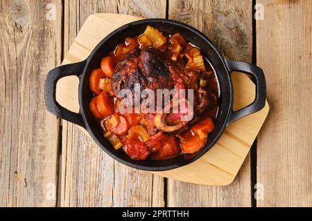 Draufsicht auf eine gusseiserne Pfanne mit Ossobuco Stockfoto