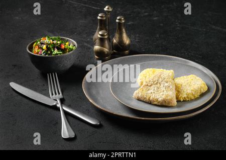 Halbfertiges Kalmare-Schnitzel in der Panade Stockfoto