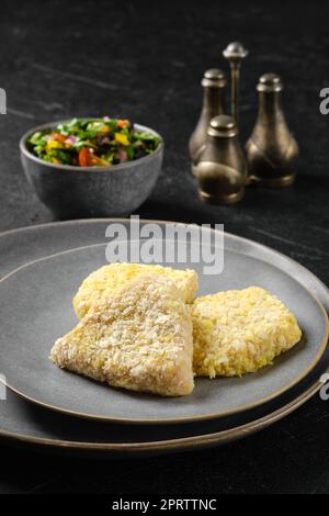 Halbfertiges Kalmare-Schnitzel in der Panade Stockfoto