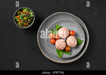 Ansicht von halbfertigen gefrorenen Kalbfleischbällchen auf einem Teller Stockfoto