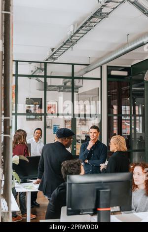 Multiethnische männliche und weibliche Geschäftsleute während des Meetings am Arbeitsplatz Stockfoto